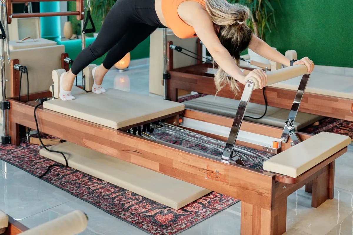 Klinik pilates — aydınlık stüdyoda reformer makinesinde kontrollü pilates egzersizi